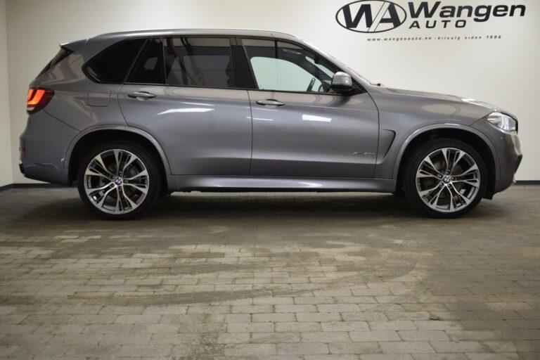 A side view of a gray SUV parked indoors on a tiled floor, with the "Wangen Auto" logo visible on the wall in the background.