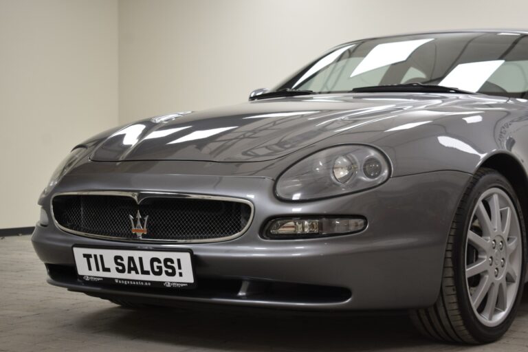 A grey Maserati car with the front half visible and a "TIL SALGS!" sign on the front license plate, indicating it is for sale.