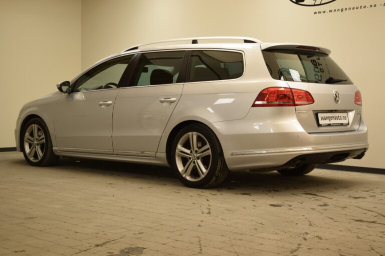 A silver Volkswagen Passat station wagon is parked indoors on a tiled floor, viewed from the rear side.