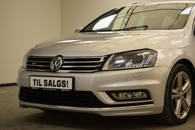 A silver Volkswagen car with a "Til Salgs!" sign displayed on the front, indicating it is for sale.