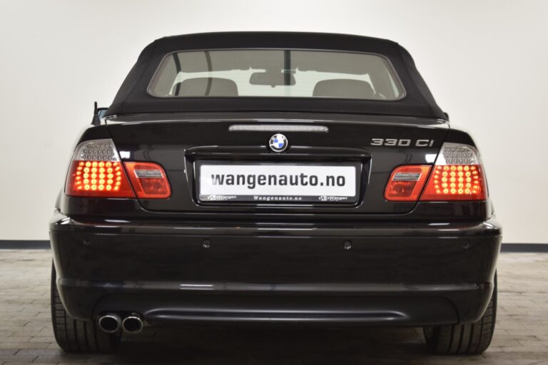 Rear view of a black BMW 330Ci convertible with its top up, displaying dual exhaust pipes and a "wangenauto.no" license plate.