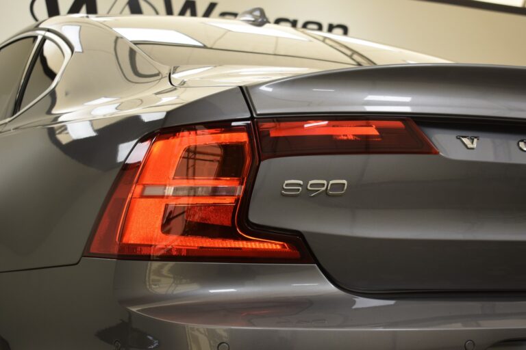 Close-up view of the rear of a gray Volvo S90, focusing on the tail light and the model badge.