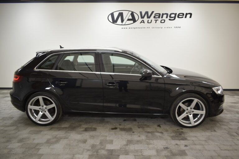 A black hatchback car is parked indoors on a tiled floor with "Wangen Auto" written on the wall in the background.