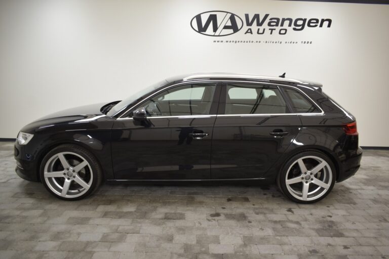 A black, four-door hatchback car parked indoors on a tiled floor in front of a white wall with a "Wangen Auto" logo.