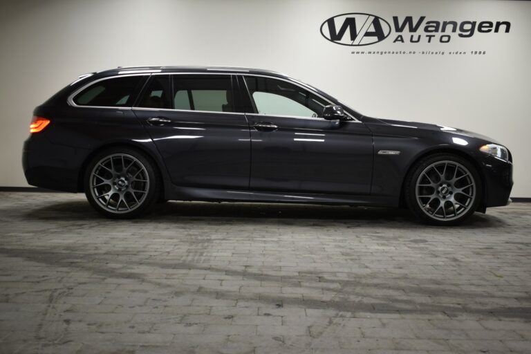 Dark gray station wagon with alloy wheels parked inside a garage next to a wall with the "Wangen Auto" logo.