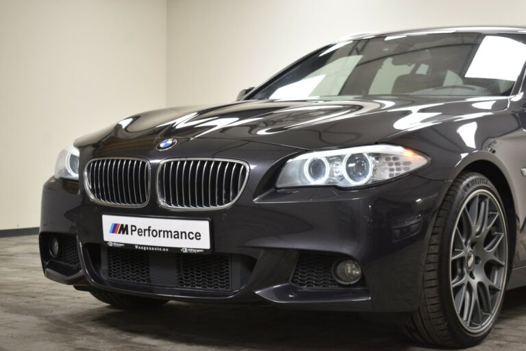 Close-up of a black BMW M Performance car, focusing on the front grille, headlights, and partial wheel.