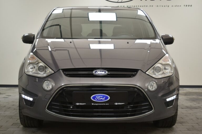 Front view of a gray Ford car with headlights on, displayed indoors on a tiled floor.