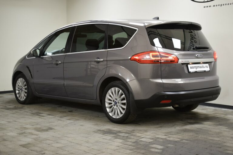 Silver minivan parked indoors on a tiled floor, viewed from the rear and side.