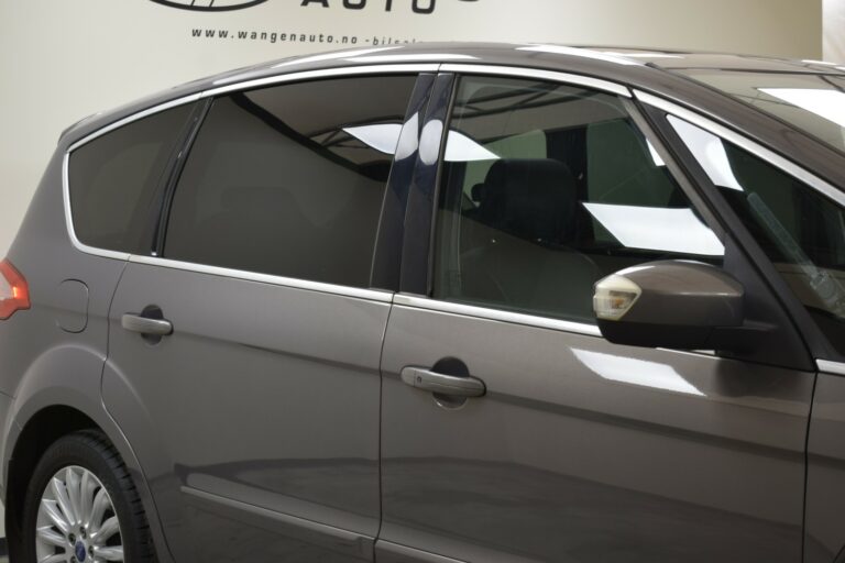 Side view of a gray car showing rear and passenger doors, with reflections visible on the windows.