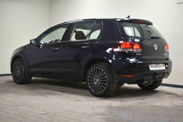 A black Volkswagen Golf hatchback is parked indoors, viewed from the rear and side.