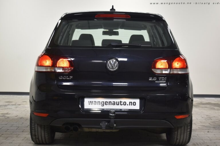 Rear view of a black Volkswagen Golf 2.0 TDI parked indoors with visible taillights and a tow hitch.