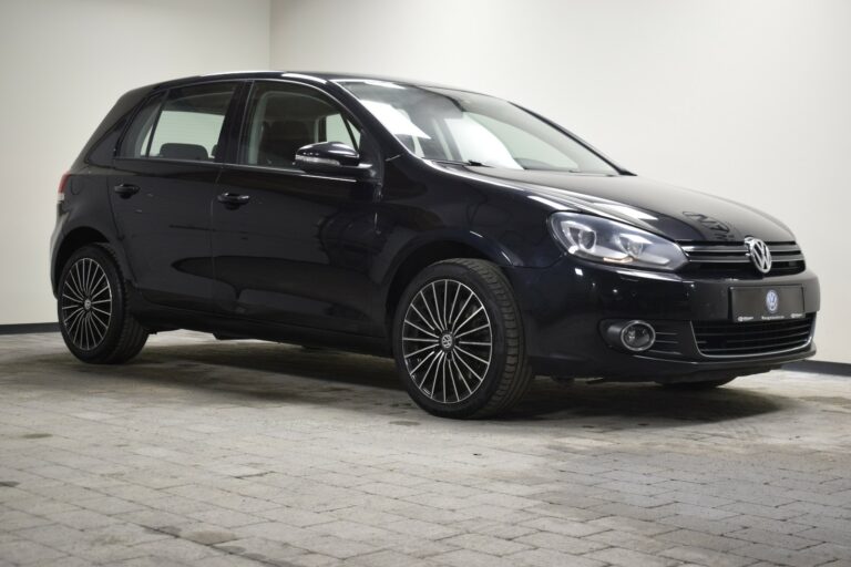 A black Volkswagen Golf is parked in a well-lit indoor space on a tiled floor.