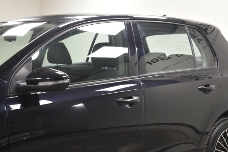 Side view of a black car showing the front and rear doors, windows, and a side mirror in an indoor setting.