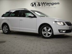 White station wagon parked indoors, showroom setting.