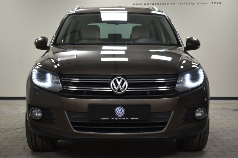 Front view of a brown Volkswagen SUV with LED headlights, parked indoors.