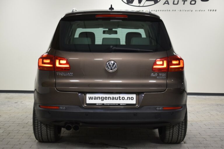 Rear view of a brown Volkswagen Tiguan 2.0 TDI parked indoors with visible taillights and exhaust pipes.