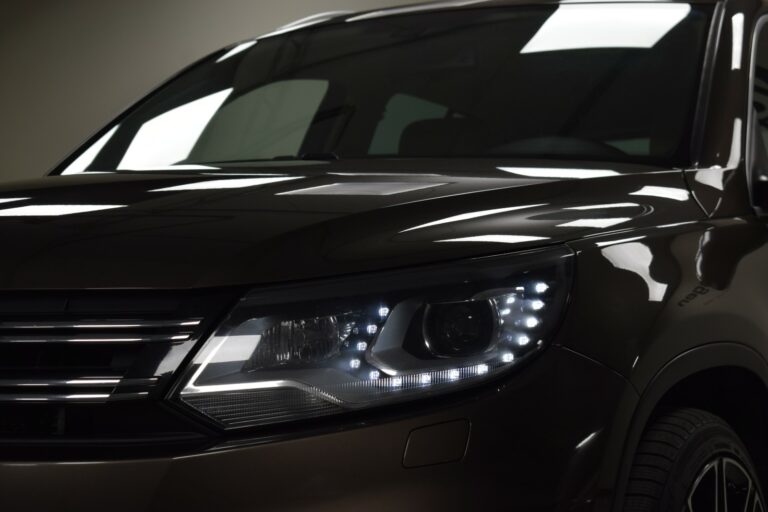 Close-up of a car's front left headlight with LED lights illuminated, showing part of the grille and windshield.