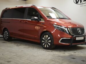 A red Mercedes-Benz van is parked indoors on a tiled floor, with a visible logo on the wall.