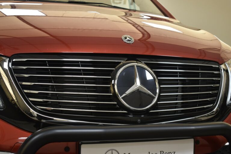 Close-up of a red Mercedes-Benz front grille and emblem.