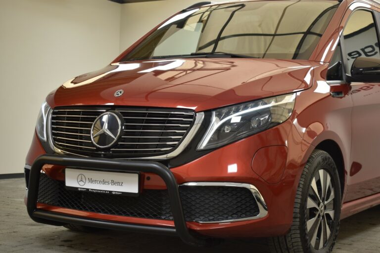 A red Mercedes-Benz van with a front grille guard, parked indoors.