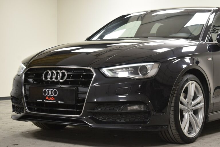 Front view of a black Audi car in a showroom.