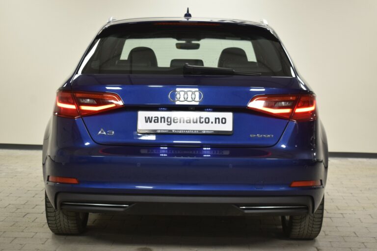 Rear view of a blue Audi A3 e-tron with illuminated taillights, displayed indoors. License plate reads "wangenauto.no".