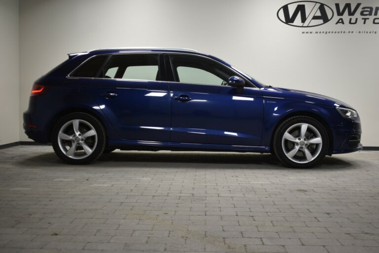 Side view of a blue SUV parked indoors on a tiled floor, with a company logo on the wall in the background.