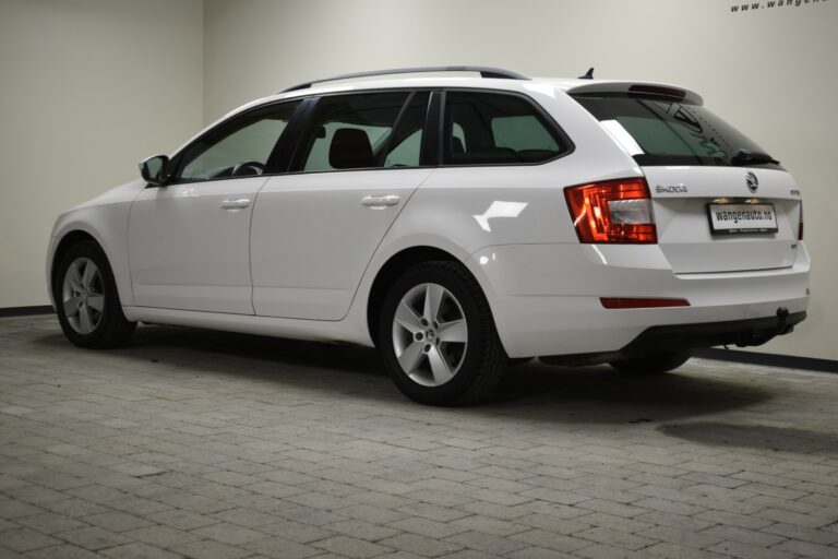 White station wagon parked indoors on a tiled floor, viewed from the rear side angle.