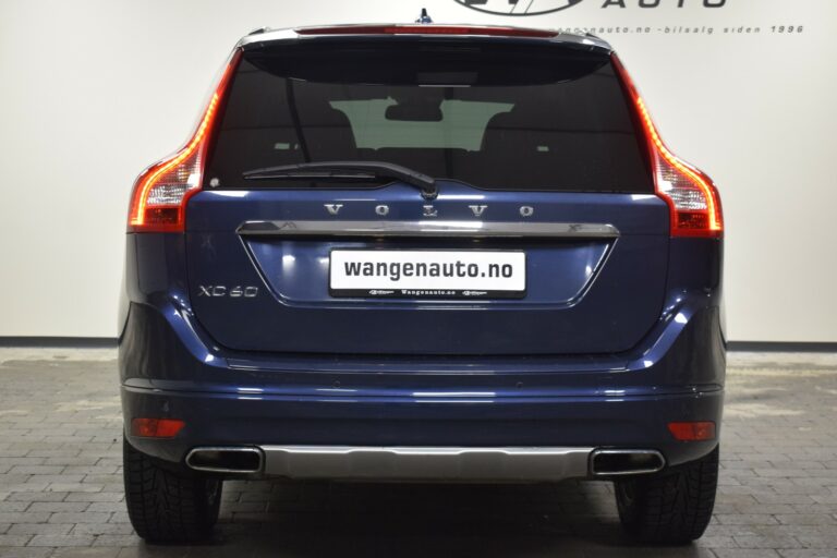 Rear view of a blue Volvo XC60 parked indoors, displaying a license plate reading "wangenauto.no.