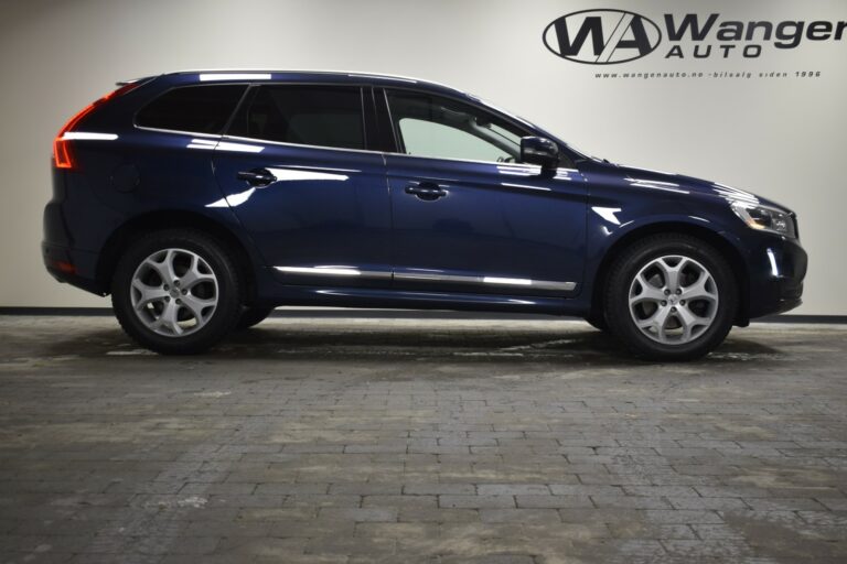 A side view of a dark blue SUV parked indoors on a tiled floor, with a company logo in the background.