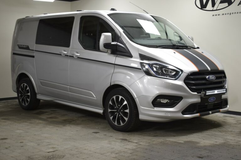 Silver Ford Transit van with black and orange stripes, parked indoors on a tiled floor, front and side view.