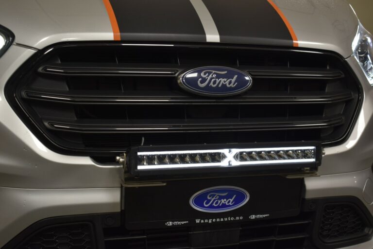 Close-up of a Ford vehicle grille with a light bar and orange and black stripes on the hood.