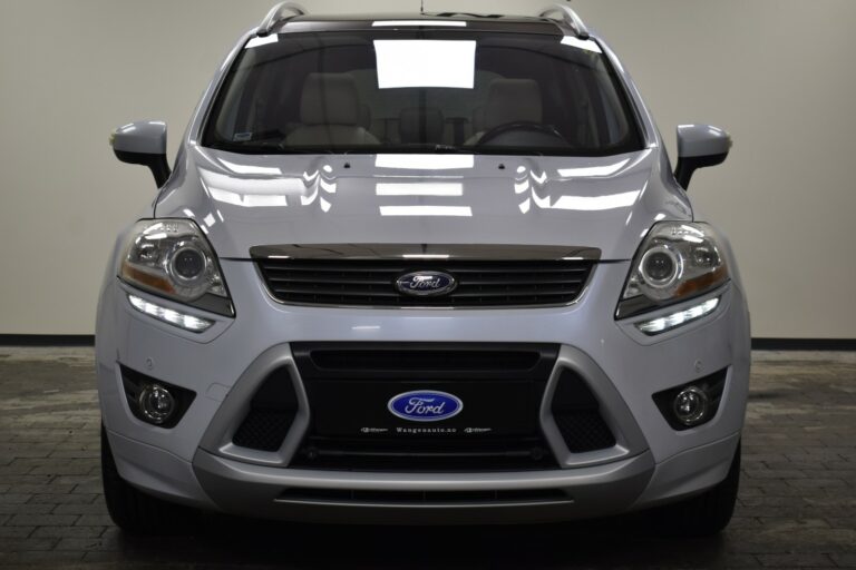 Silver Ford SUV photographed from the front in a showroom, highlighting the grille, headlights, and brand logo.