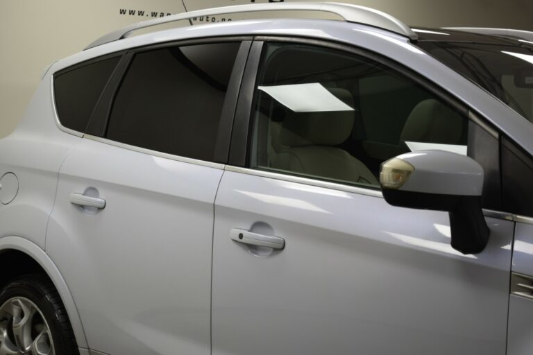 Close-up of a white car's side, showing the rear passenger door and tinted windows.