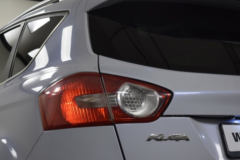 Close-up of the rear section of a silver SUV with a visible taillight and a partial view of a license plate.